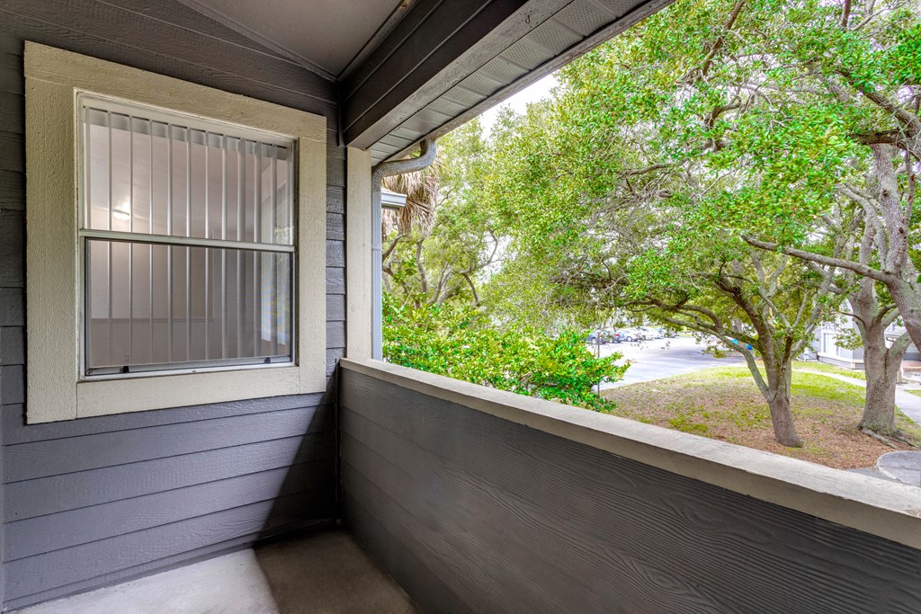 a balcony with a view of trees and a street