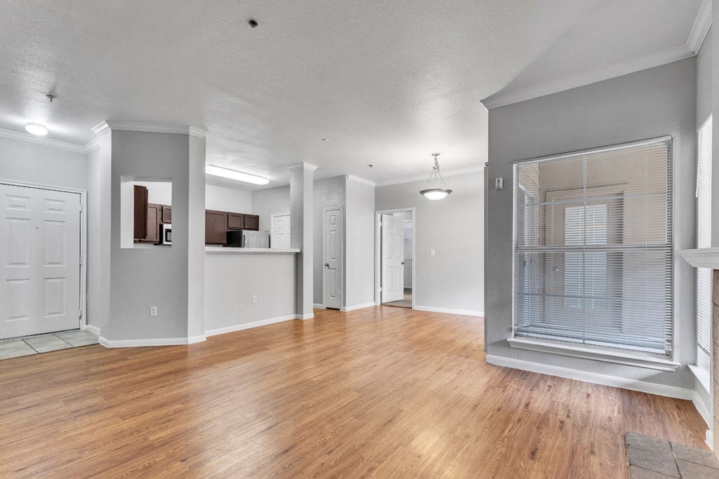 A spacious room with wooden floors and white walls.