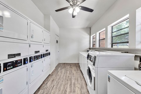 a laundry room with white appliances and a ceiling fan