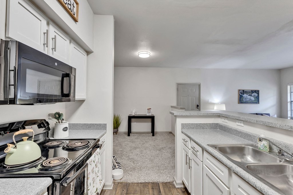a kitchen with white cabinets and a stove and a sink