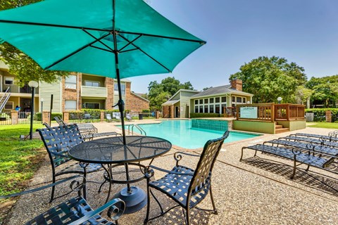 a swimming pool with patio furniture and umbrellas