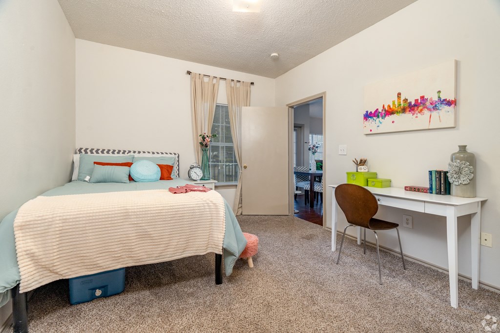 a bedroom with a bed and a desk with a chair