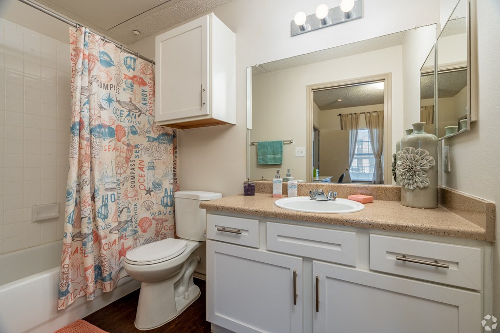 a bathroom with a shower curtain and a toilet and sink