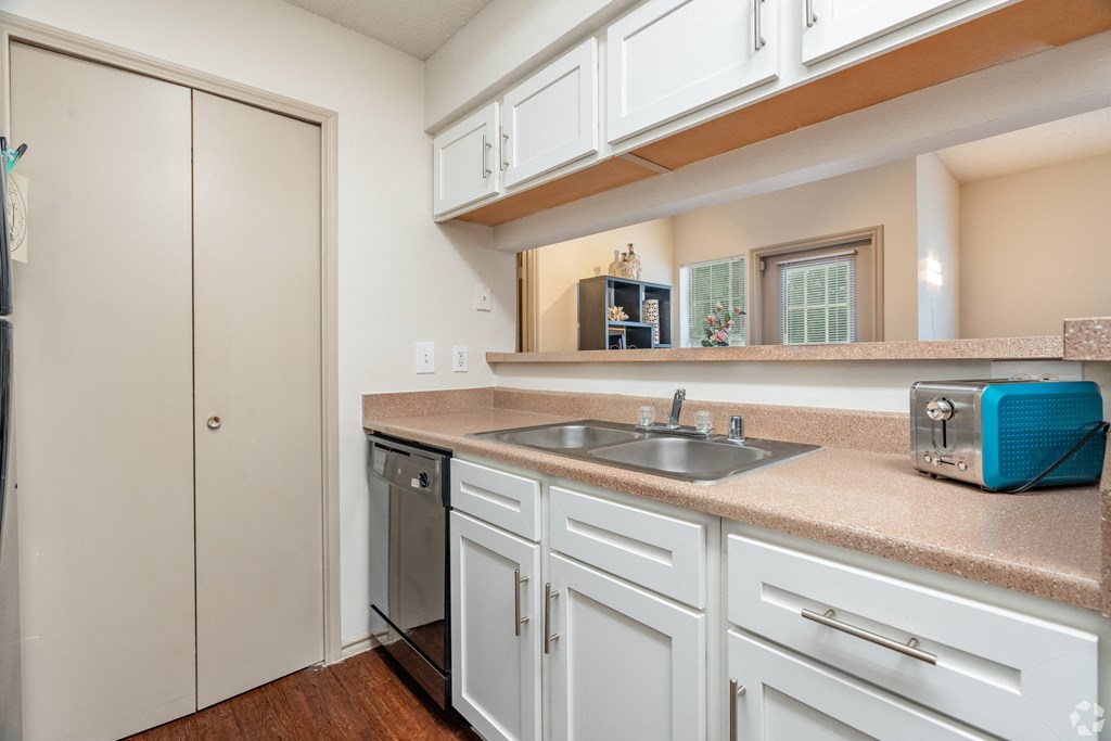 a kitchen with white cabinets and a sink and a refrigerator