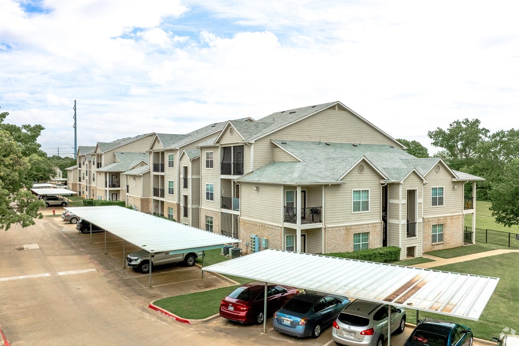 awnings in front of an apartment building with cars parked outside