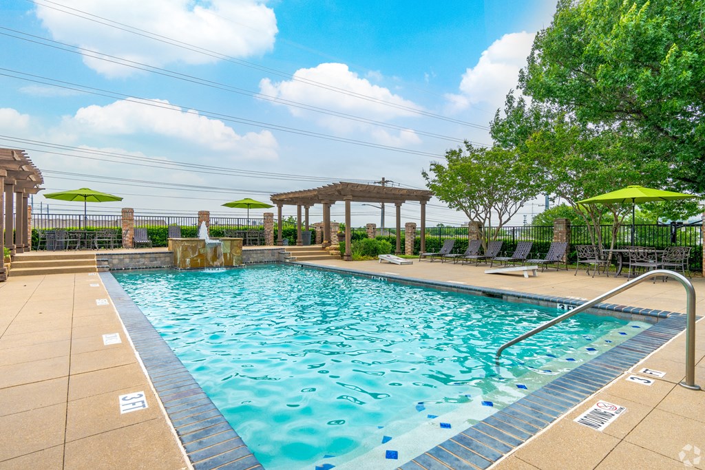 a swimming pool with umbrellas in a resort style pool