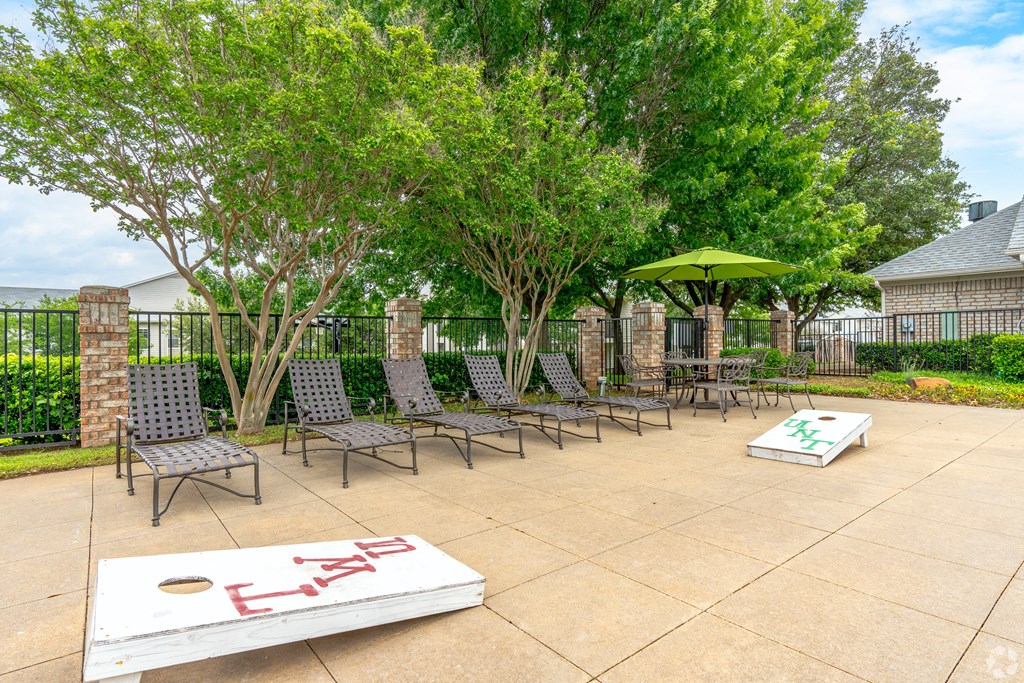 an outdoor lounge area with chairs and tables and umbrellas