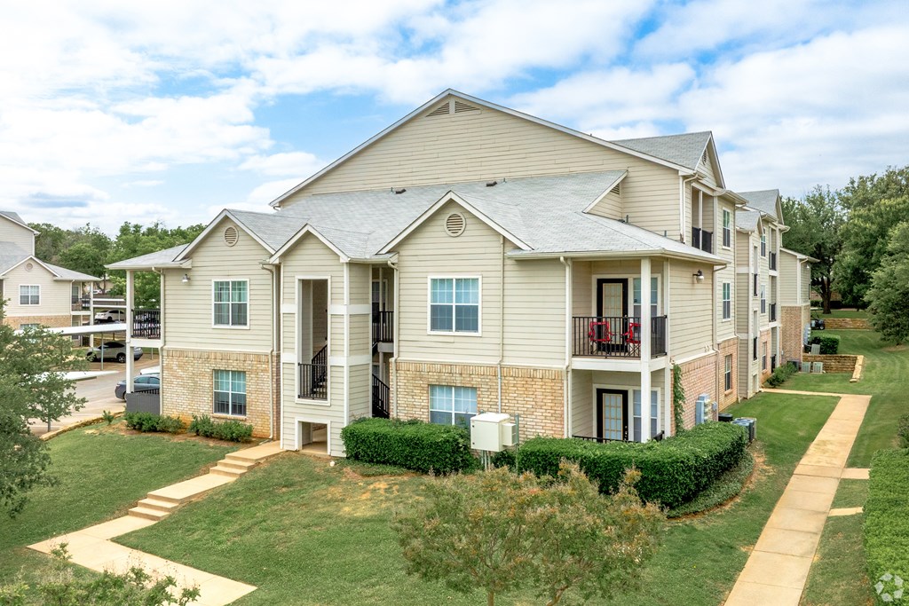 the outlook of an apartment building with lawns and trees