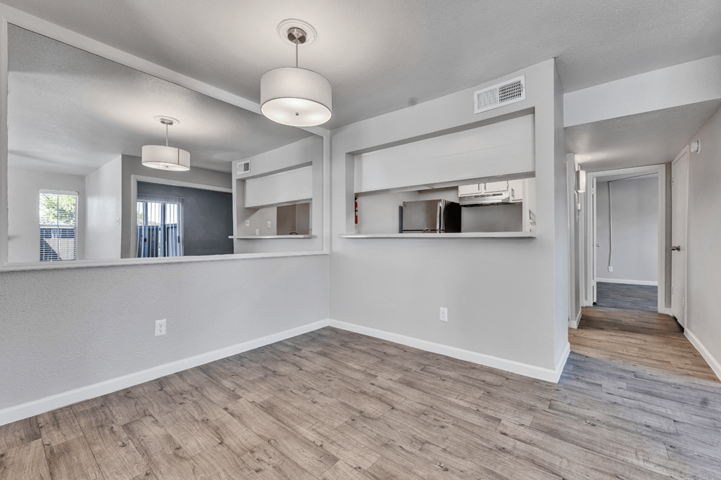 A spacious room with a wooden floor and white walls.