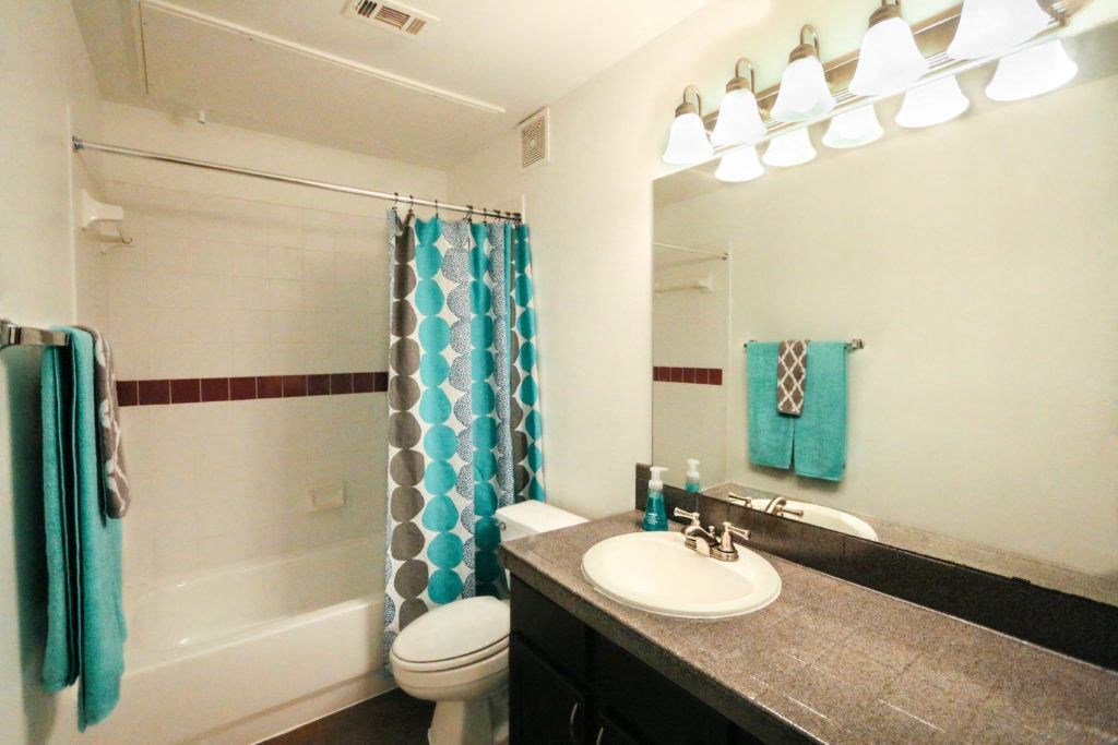 a bathroom with a sink and a shower and a toilet