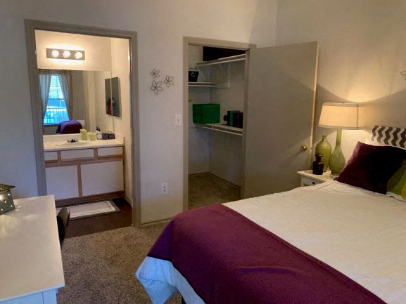 a bedroom with a bed and a bathroom with a sink