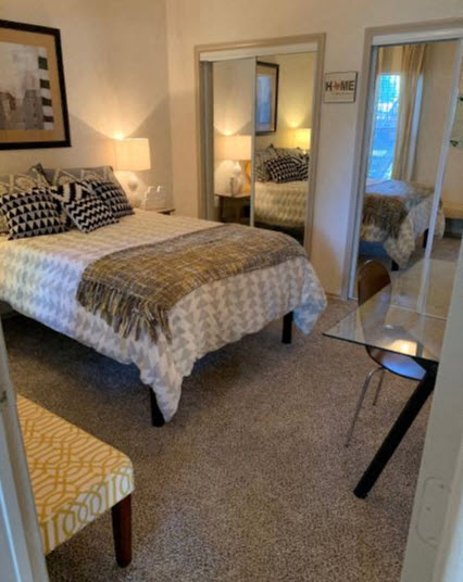 a bedroom with a bed and a glass table