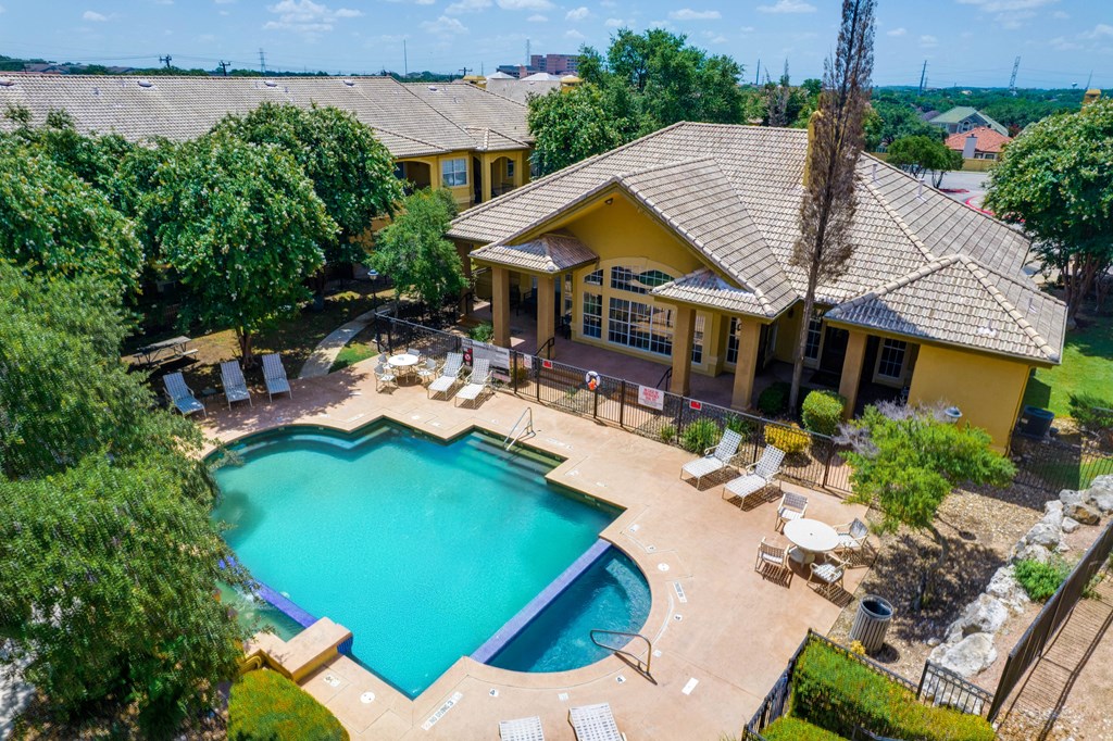 a aerial view of a pool and a house