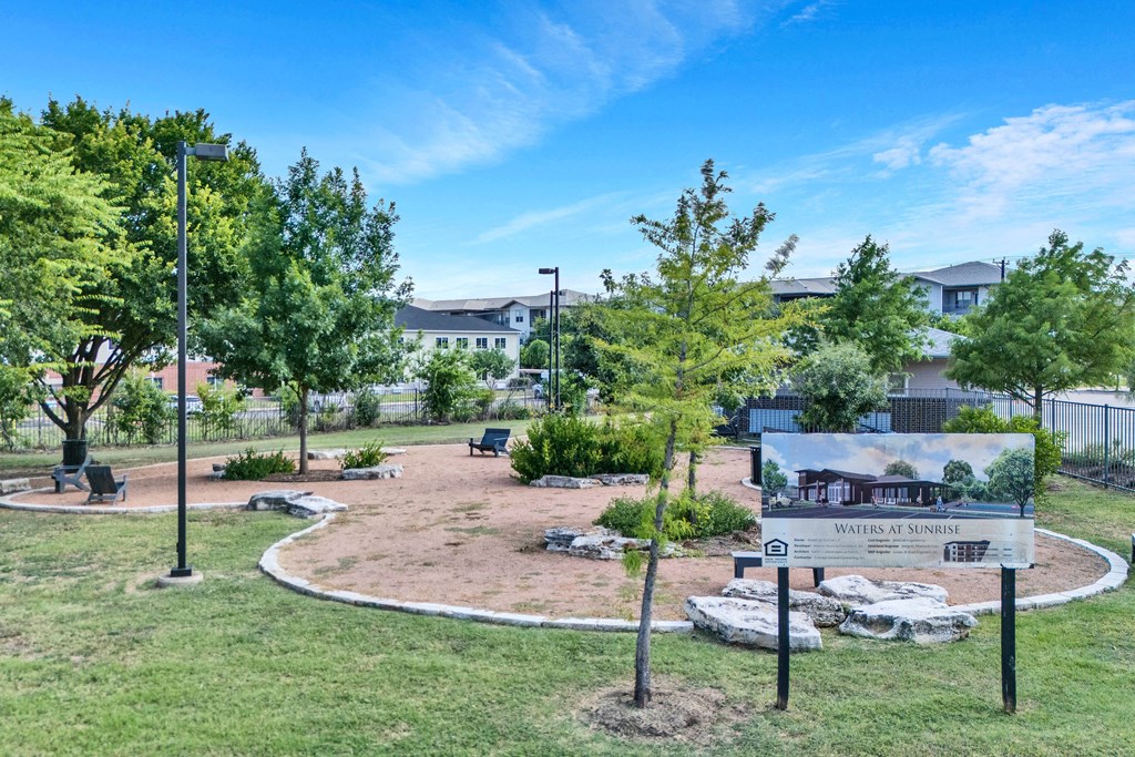 a park with trees and a sign in front of a building