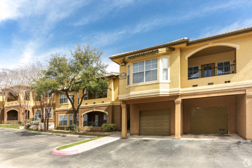 a building with two garages and a tree in front of it