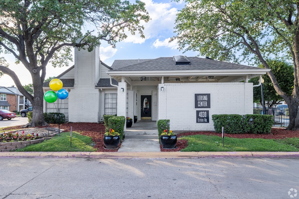 the front of a white house with balloons
