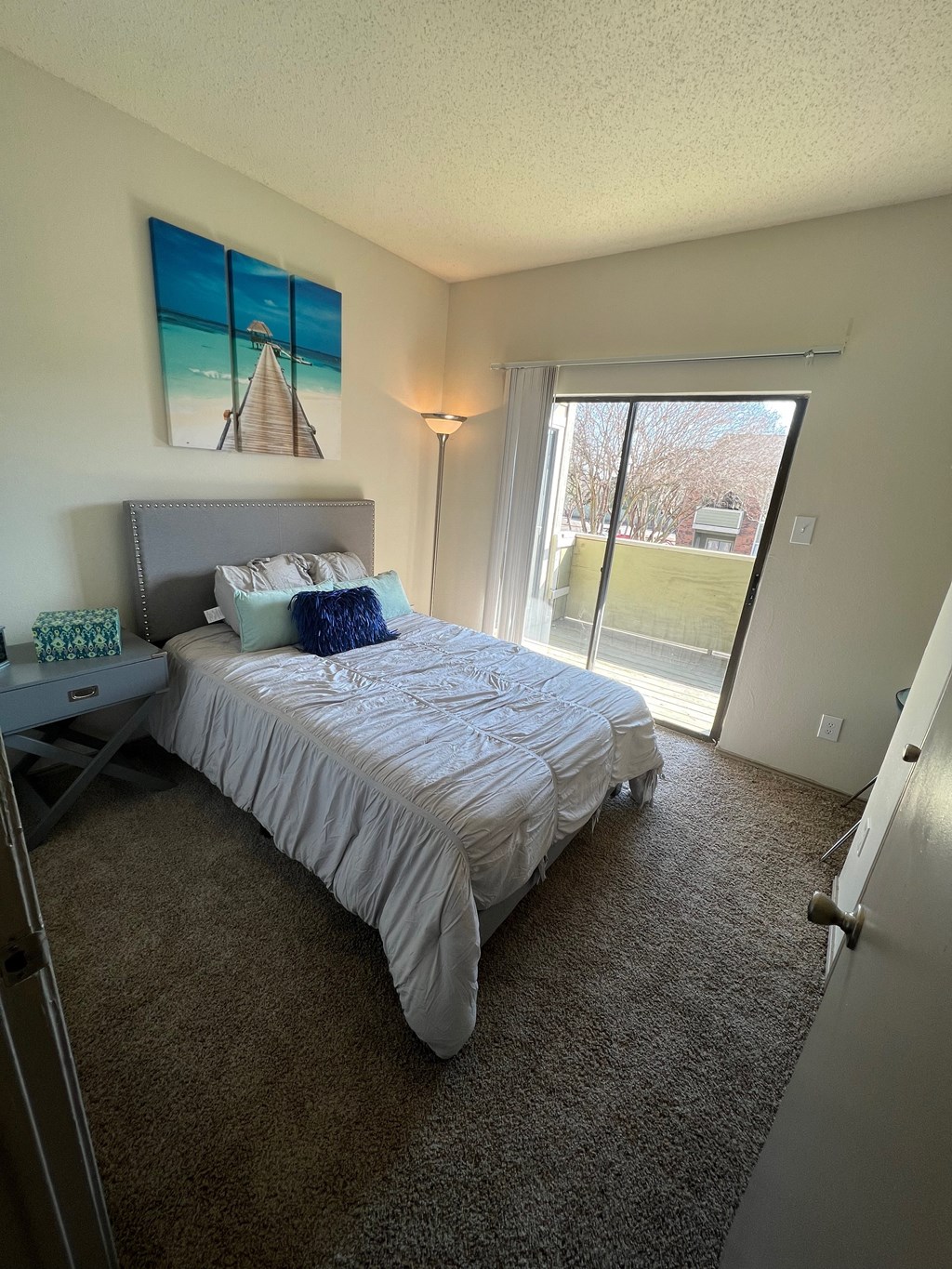 a bedroom with a large bed and a sliding glass door
