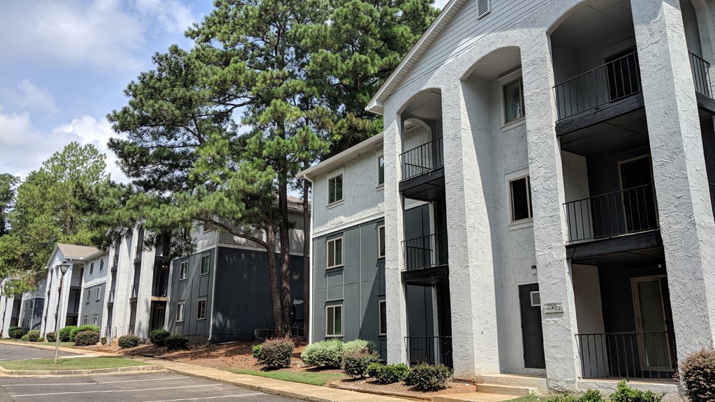 a row of apartment buildings with balconies and trees