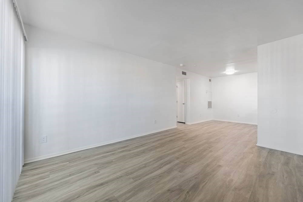 an empty living room with white walls and wood floors