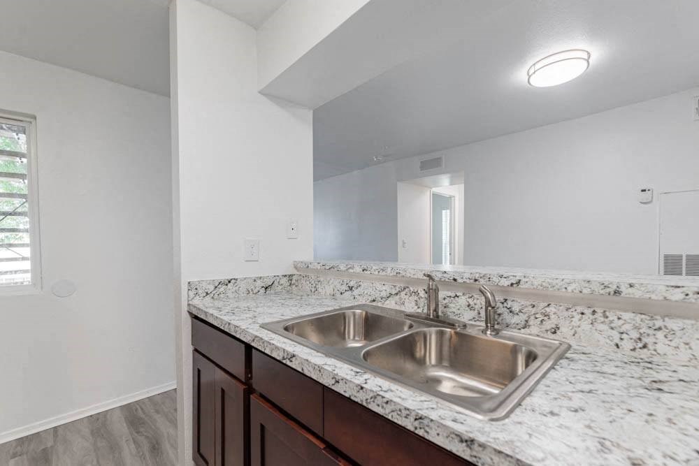 the spacious kitchen has granite counter tops and a stainless steel sink