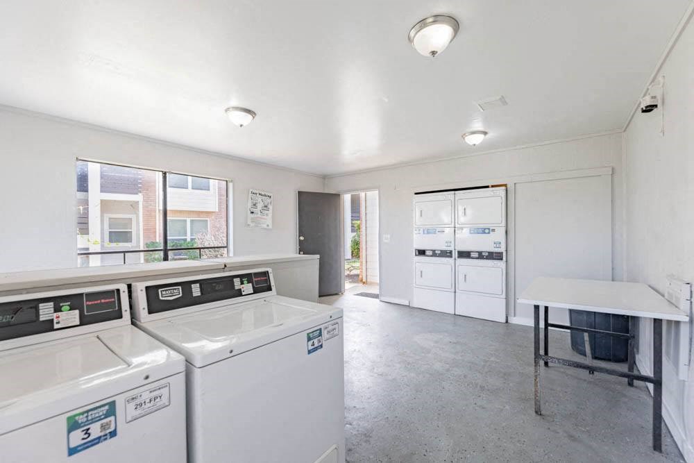 a laundry room with two washing machines and a table