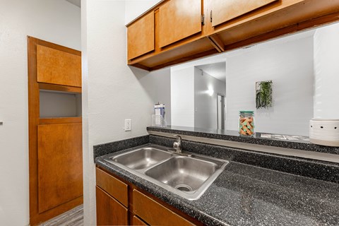 the kitchen has granite counter tops and a stainless steel sink