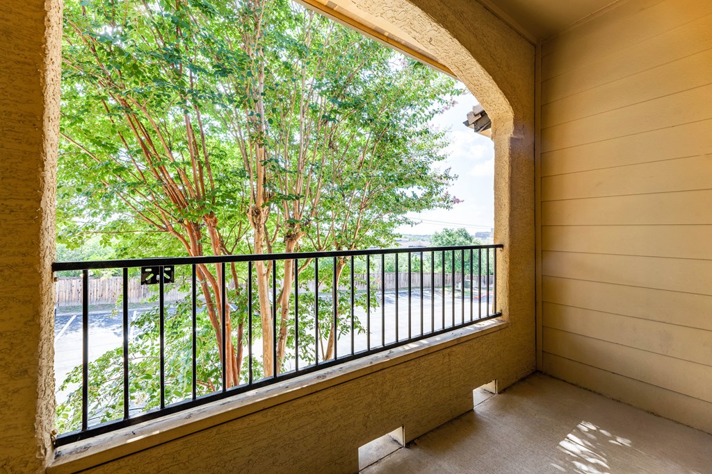 a balcony with a view of the trees and the river