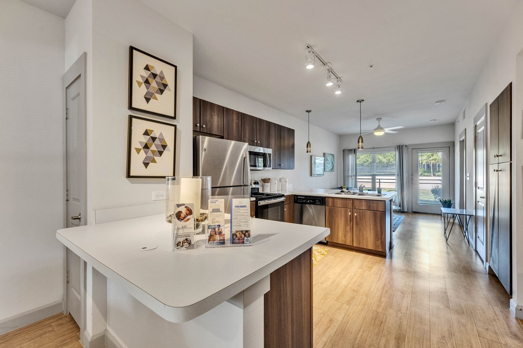an open kitchen and living room with a large island with a white counter top