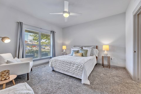 a bedroom with a bed and a large window