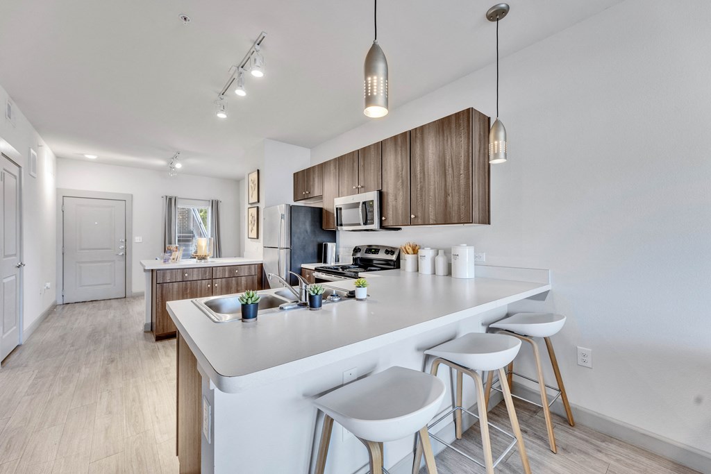 an open kitchen with a large island with three stools
