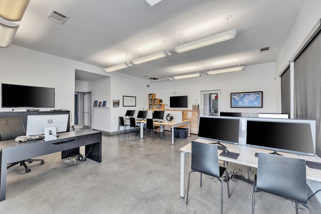 a large classroom with desks and chairs and monitors