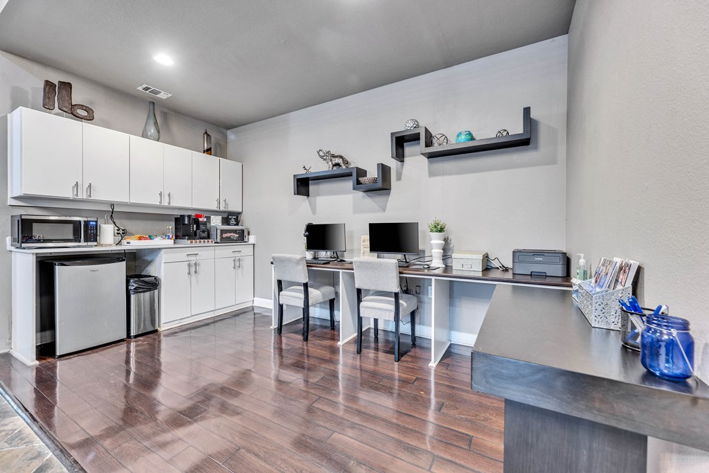 a kitchen with white cabinets and stainless steel appliances and a table with chairs