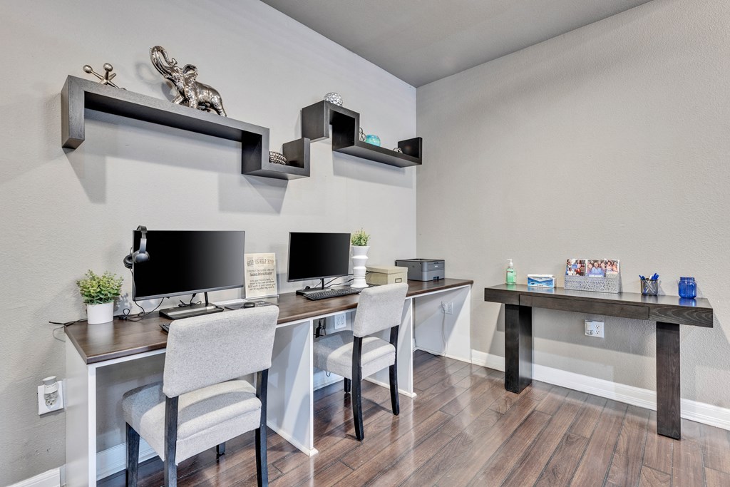 a home office with two desks and two computer monitors