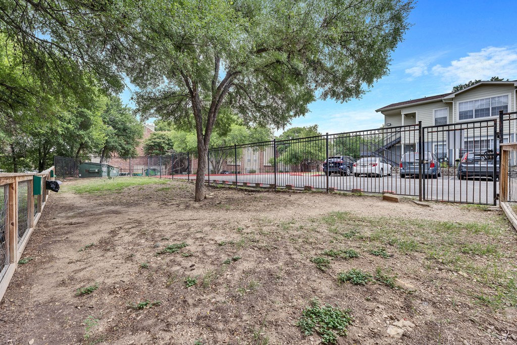a fenced in yard with a tree and a fence
