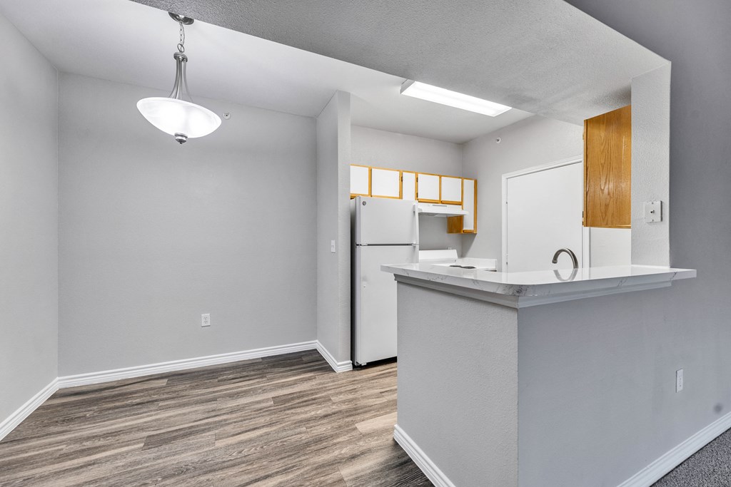 an empty kitchen with a counter top and a refrigerator