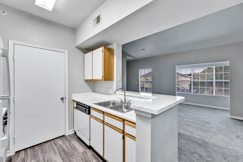 a kitchen with white cabinets and a sink and a refrigerator