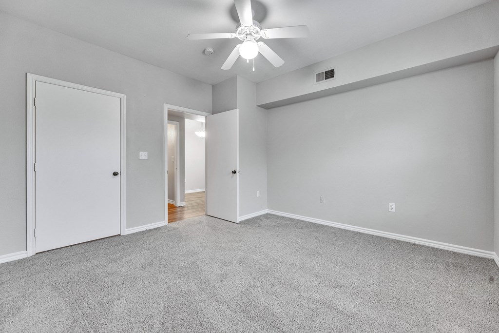 the living room of an empty house with a ceiling fan