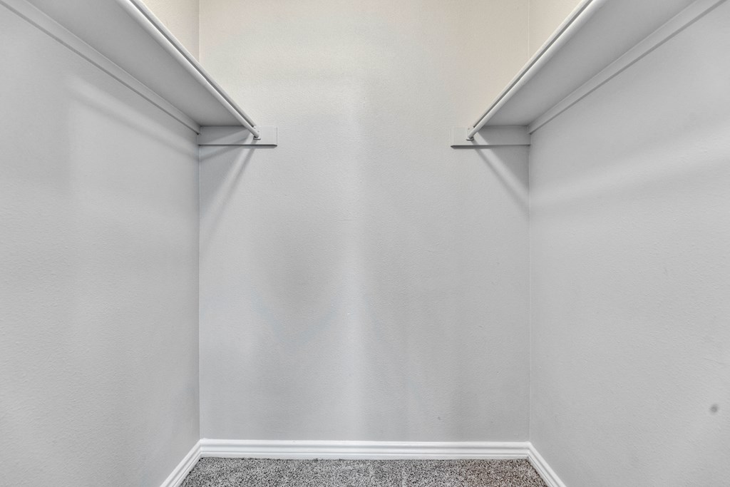 an empty room with white walls and two white shelves on the wall