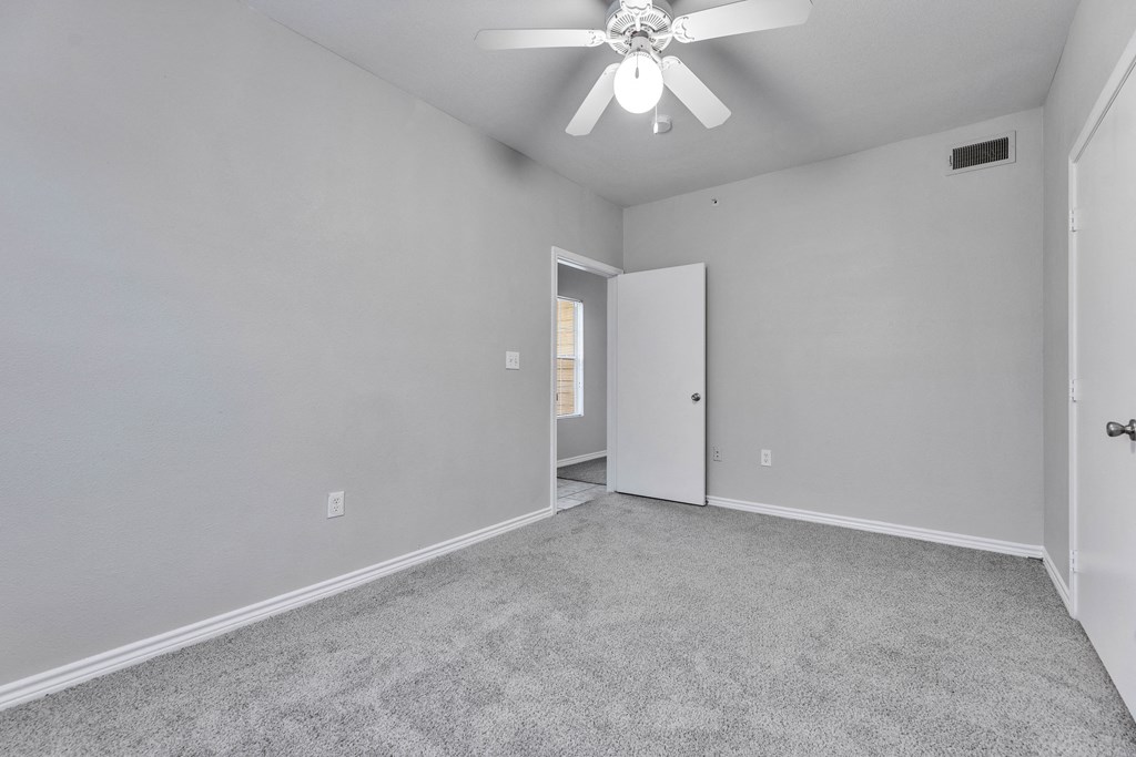 the living room of an empty house with a ceiling fan
