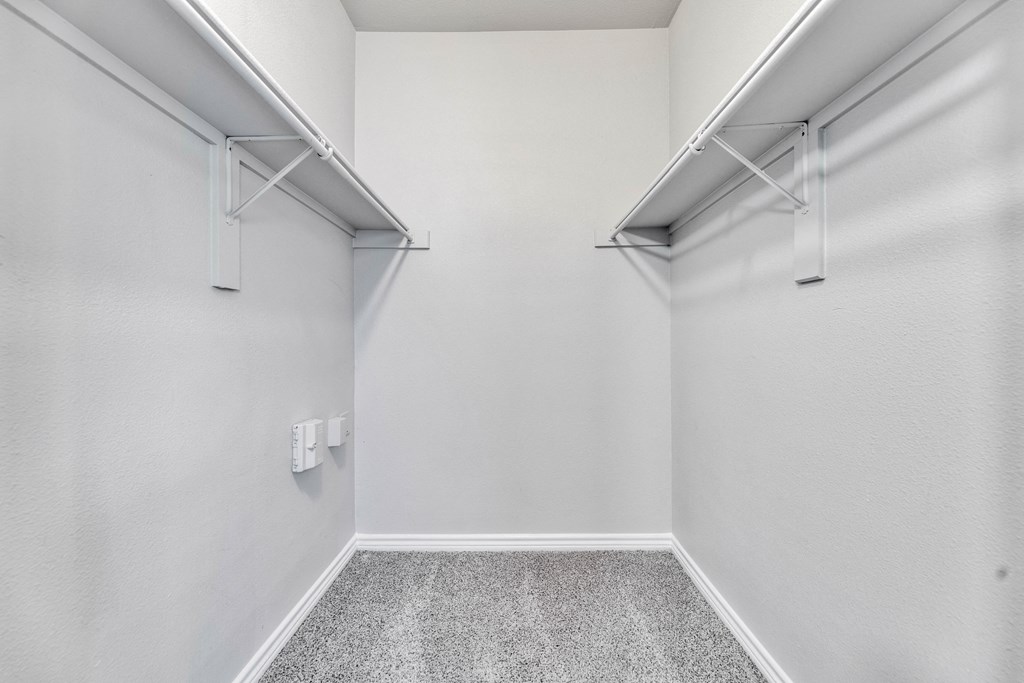 an empty room with white walls and two empty closet doors