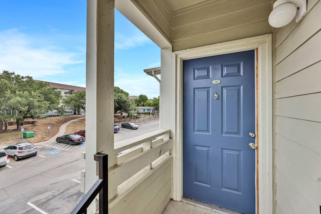 the view from the front door of a condo with a blue door