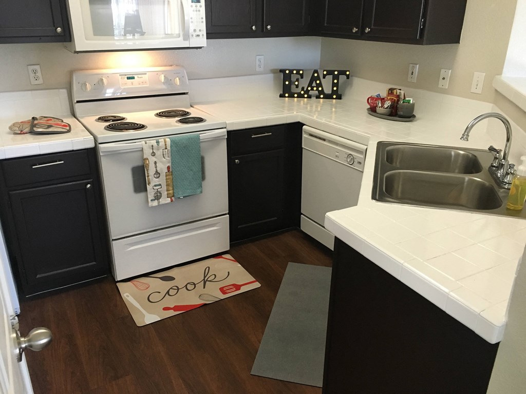 a kitchen with white appliances and black cabinets