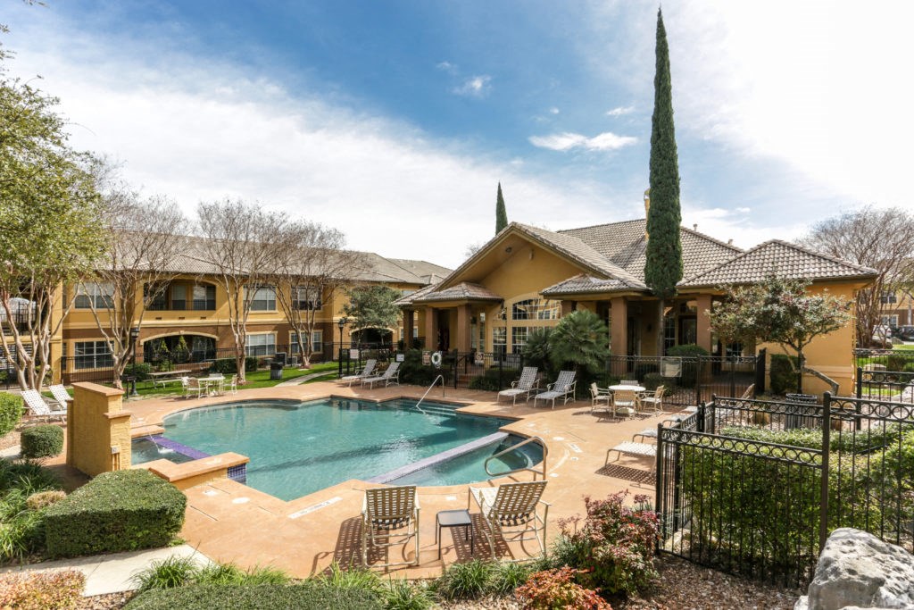 a swimming pool in front of a house with a resort style pool