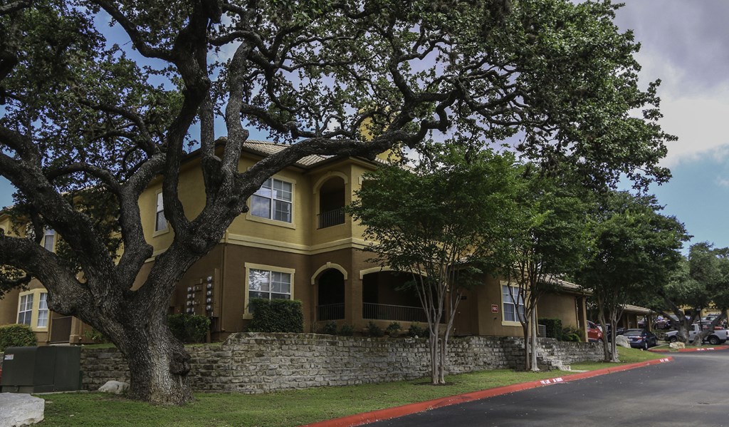a large yellow house with a large tree in front of it