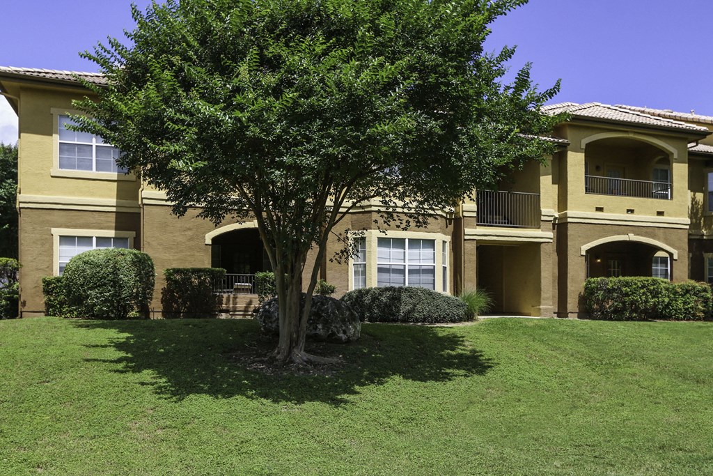 a large yellow house with a tree in front of it