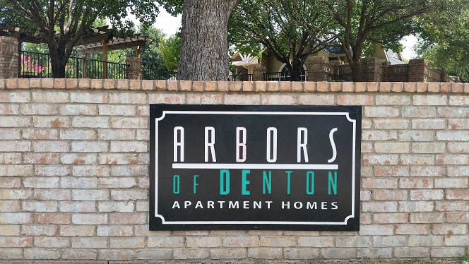 a sign on the side of a brick wall