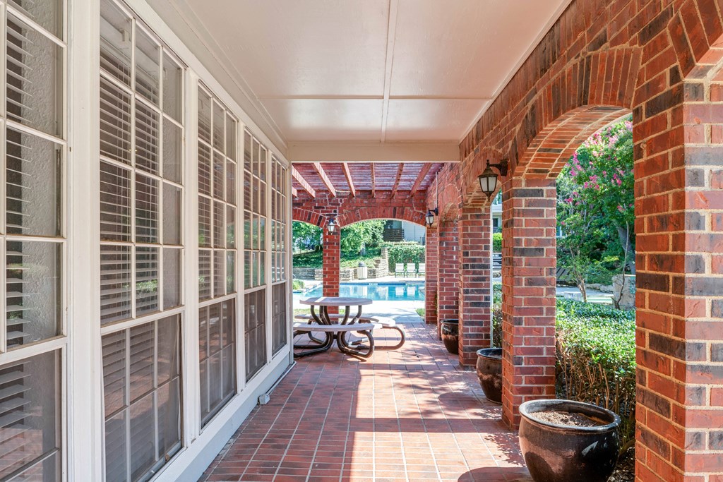 a covered porch with a table and a pool