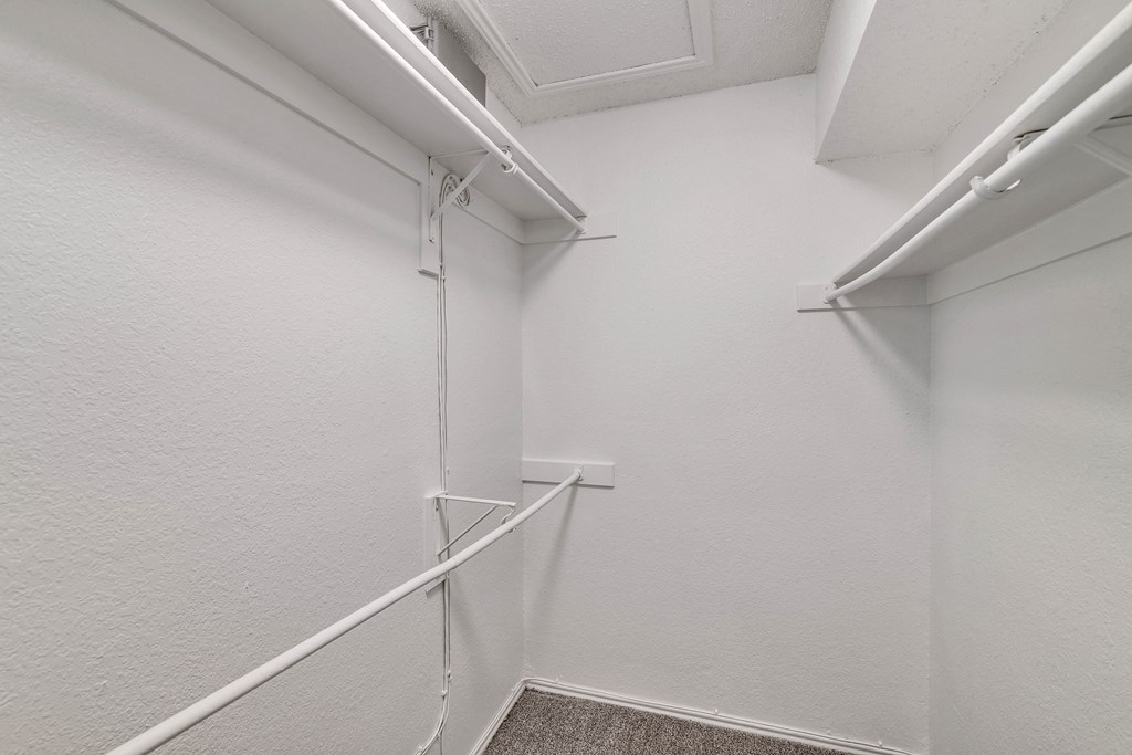 an empty closet with white walls and white railings in a bathroom