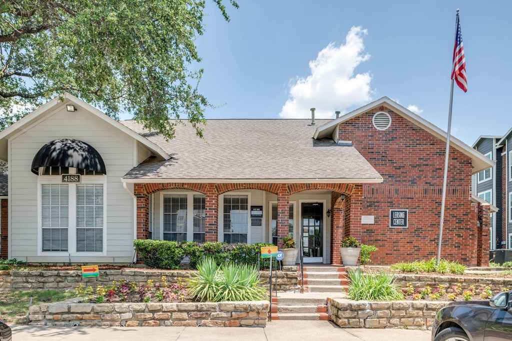 the front of a brick house with an flag on the side of it