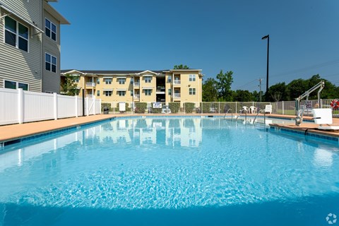 a swimming pool with an apartment building in the background